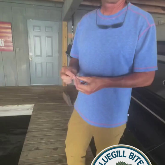 Man fishing inside a boathouse using Bluegill Bites.